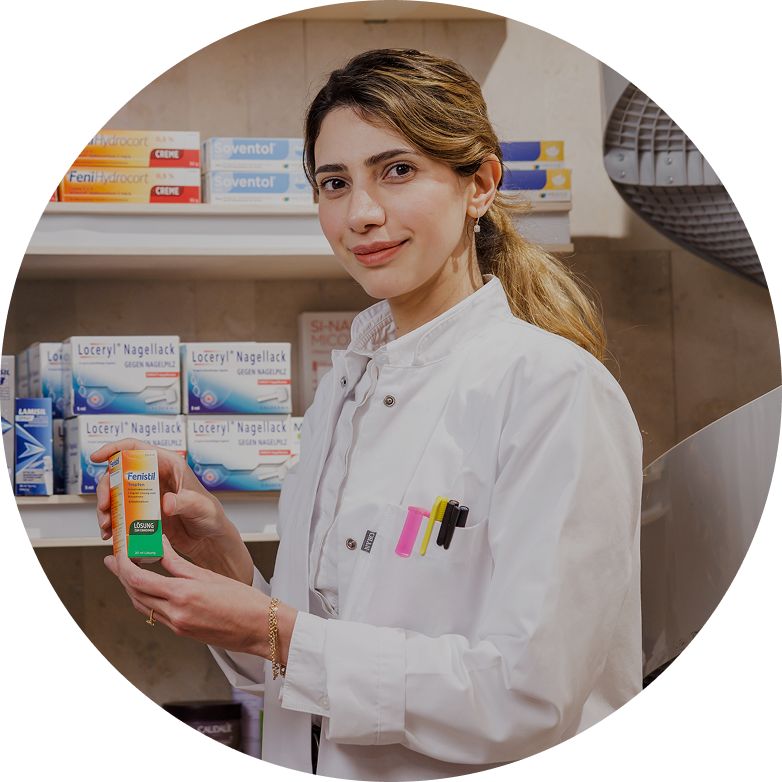Freundliche Apothekerin im weißen Kittel empfiehlt Medikament in moderner Apotheke mit gut sortierten Regalen.