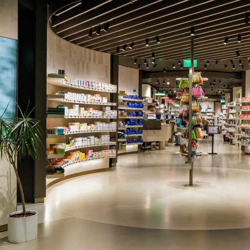 Modernes Apotheken-Interieur mit digitalem Display, Holzregalen, Pflanzen und übersichtlich präsentierten Gesundheitsprodukten.